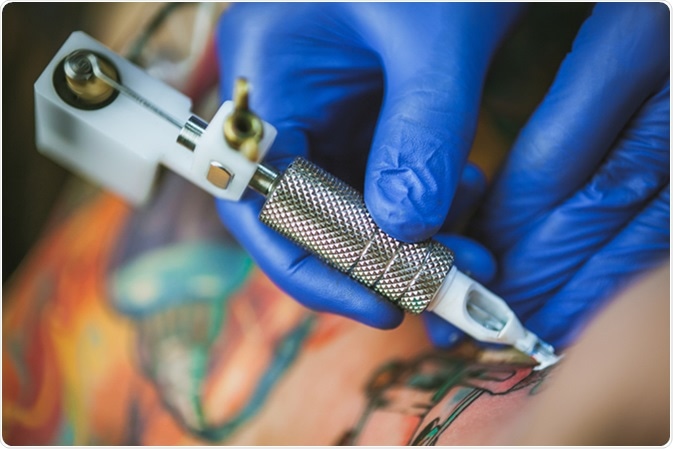 Tattooist makes a tattoo. Closeup. Image Credit: Mikhail_Kayl / Shutterstock