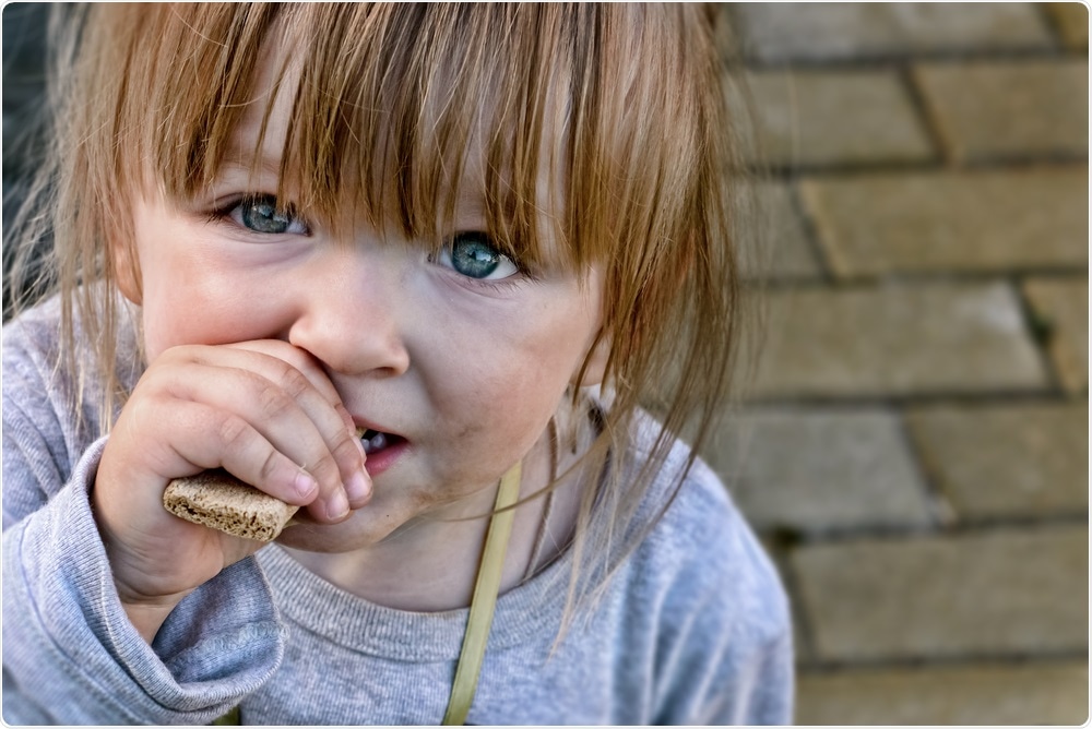 Child eating bread - hungry and malnourished