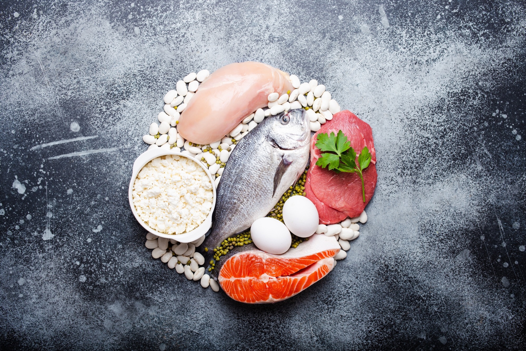 Different types of natural healthy foods contain protein: fish, meat, chicken, eggs, dairy products, and beans. Image Credit: Elena Eryomenko / Shutterstock