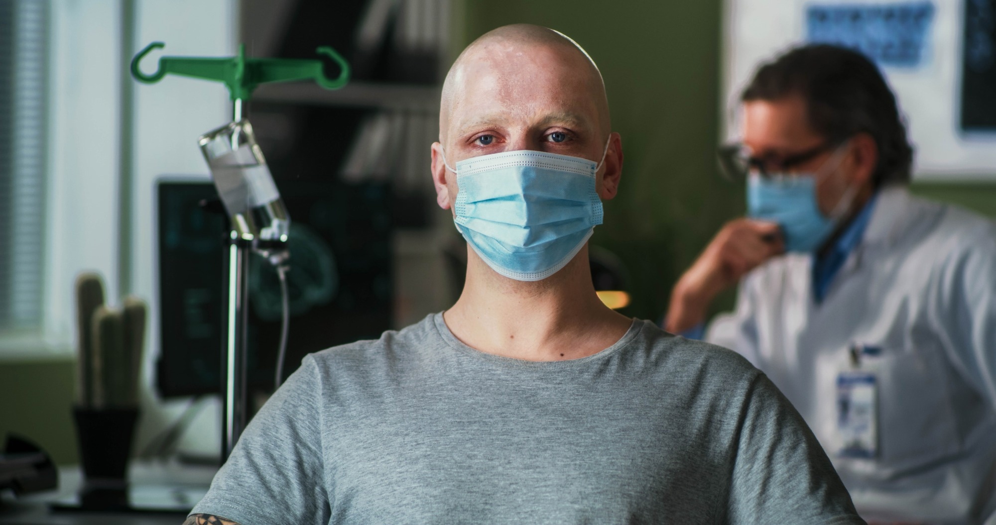 Bald man with cancer wearing mask and looking at camera