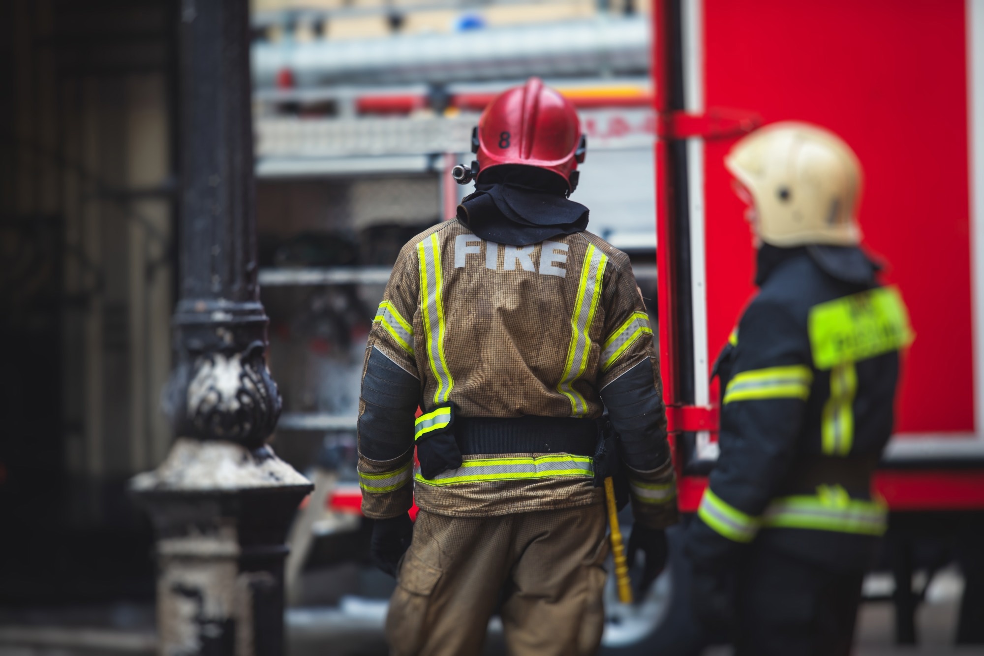 Group of fire men in uniform during fire fighting operation in the city streets